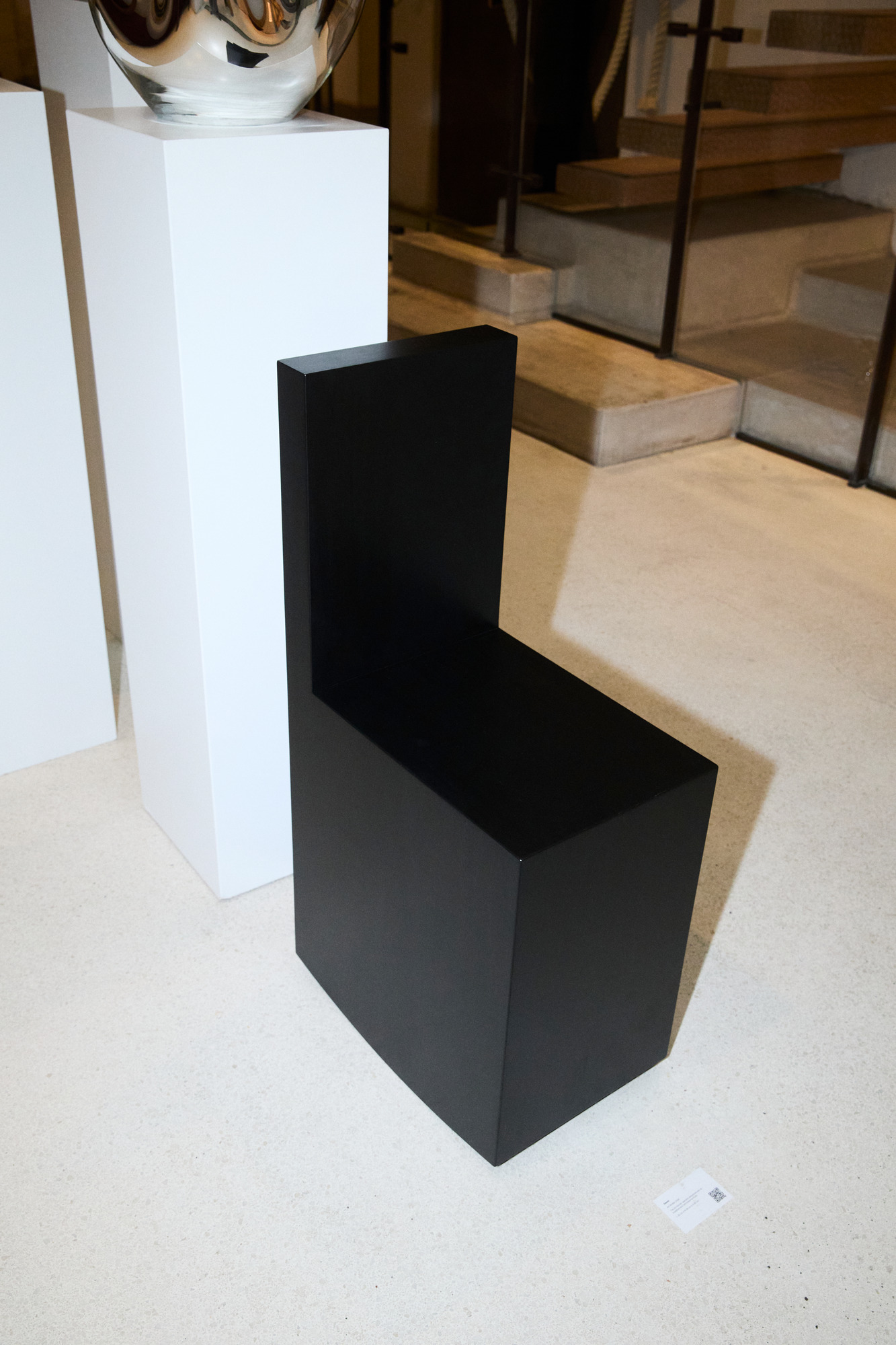 Art Rocker by Studio Goons in black satin on a pale stone floor at OGATA Paris.
